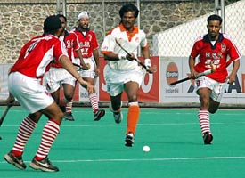 Indian Airlines striker Dhanraj Pillay (centre) tries to get past BSF defenders during a match of the Surjit Memorial Hockey Tournament in Jalandhar on Monday. 