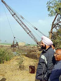 Mr Sukhjinder Singh Randhawa, Parliamentary Secretary for Agriculture, supervises an operation launched for reviving village ponds in the Dera Baba Nanak area. 