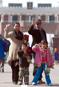 Cricket fan Gurpreet and her son wave to mediapersons before crossing over to Pakistan via the Wagah joint checkpost on Thursday