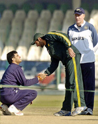 Shahid Afridi shakes hands with Sourav Ganguly as India�s coach Greg Chappell looks on prior to their practice session at the Gaddafi Stadium in Lahore on Thursday