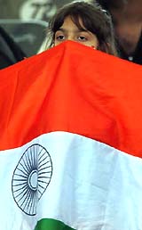 A young cricket fan holds the Indian national flag during the third day's play of the first Test match between India and Pakistan in Lahore on Sunday