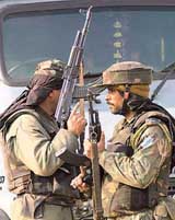 Paramilitary personnel take up positions after a grenade explosion at Budshah Chowk in Srinagar on Saturday