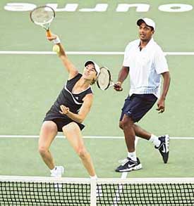 Martina Hingis of Switzerland plays a shot while partner Mahesh Bhupathi watches during their mixed doubles match against Lisa Raymond of the US and Jonas Bjorkman of Sweden at the Australian Open on Tuesday. 