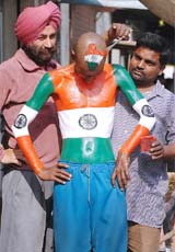 Sudhir Kumar Chaudhary, a cricket fan, has the Indian flag painted on his body by an artist in Amritsar