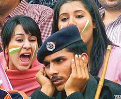 Indian female cricket fans yell at a Pakistani policeman as he sits in the crowd during the third one-day between Pakistan and India in Lahore on Monday