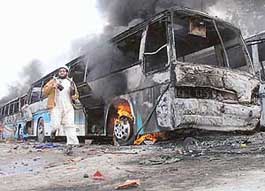 A Pakistani man runs past a bus set on fire by protesters in Peshawar on Wednesday. Three persons died, including a young boy, during violent protests in Pakistan on Wednesday against cartoons of Prophet Mohammad published in European newspapers, security officials said.