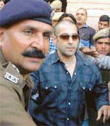 Film star Salman Khan is escorted by policemen through a crowd outside the District Courts in Jodhpur