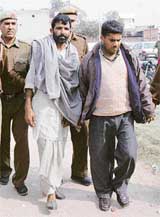 School teacher Rajesh and Niranjan, accused of raping a Class VIII girl in Ambala, being brought to a court