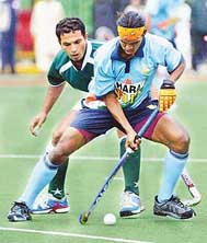 India�s Parbodh Tirkey and Adnan Maqsood of Pakistan fight for the ball during the fourth match of the Indo-Pak hockey series in Lahore on Wednesday.