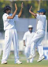 Board President�s XI bowler Munaf Patel and team-mate Pragyan Ojha celebrate the dismissal of Mathew Hoggard of England on the first day of a three-day practise match in Vadodara on Thursday