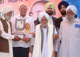 The BJP MP, Mr Dara Singh, honours a contemporary of Mohmmad Rafi at Kotla Sultan Singh village, near Amritsar, on Tuesday. Also seen in the picture is Mr Navjot Singh Sidhu, BJP MP.