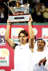 Rafael Nadal of Spain holds the trophy after winning the Dubai Open tennis tournament on Sunday