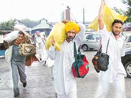 Farmers with cotton seed bags purchased from Gujarat come out of Bathinda railway station on Saturday.