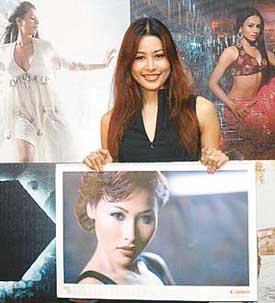 A model carries a Canon calendar page with her photograph at its launch in New Delhi on Thursday.