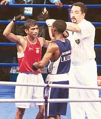 The referee raises the arm of Jitender Kumar  after his flyweight 51kg quarterfinal match against Lechedzani Luza of Botswana at the Commonwealth Games
