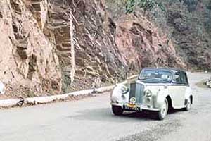 A vintage car, taking part in the Himalaya Rally for Classic Cars, motors down the national highway near Kumharatti