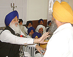 SGPC chief Avtar Singh stops Mr Karnail Singh Panjoli, an opposition member, during the budget session of the Shiromani Committee in Amritsar on Thursday. 