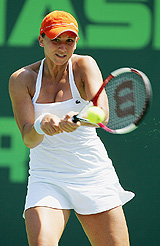 Tatiana Golovin of France returns a shot to Jie Zheng of China during the quarterfinal of the Nasdaq-100 Open at the Tennis Centre at Crandon Park in Miami on Wednesday