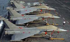 A French sailor jogs past aircraft parked aboard French aircraft carrier Charles de Gaulle in Goa on Saturday
