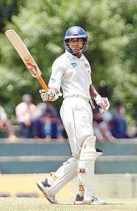 Sri Lanka�s Kumar Sangakkara raises his bat after scoring a half century on the first day of the second Test match against Pakistan at the Asgiriya cricket ground in Kandy on Monday. 