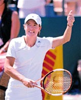 Justine Henin-Hardenne of Belgium waves to the crowd after defeating Karolina Sprem of Croatia at the Family Circle Cup Tennis Tournament in Charleston, South Carolina, on Thursday