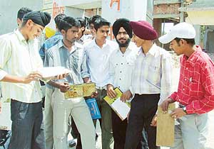 Students of plus two of Bhagta Bhai wait for their roll numbers prior to their re-examination at a centre in Bathinda on Thursday.