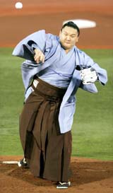 Mongolian new champion or ozeki sumo wrestler Hakuho throws a ceremonial pitch at the start of Japan�s professional baseball Central League game between the Yokohama Bay Stars and the Hanshin Tigers at Yokohama Stadium, south of Tokyo, on Wednesday
