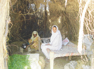 Two women, whose house was razed, sit outside an Army bunker near the Khem Karan border on Wednesday. 