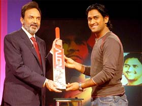 Prannoy Roy, Chairman, NDTV, receiving an autographed bat from Mahendra Singh Dhoni marking the commencement of their alliance, in New Delhi