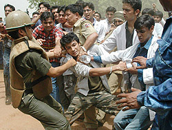 The police arrests an agitating medical student during a protest over the government’s proposed reservation policy in New Delhi on Friday.