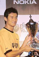 Indian football star Baichung Bhutia holds a trophy during the launch of the �Defend Your Turf� Futsal Challenge street football series in New Delhi on Friday