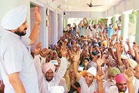 Residents of Jhumba Bhaika village raise their hands in protest against the alleged encroachment on a widow�s land at the village, near Bathinda, on Wednesday.