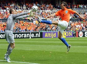 Australian goalkeeper Mark Schwarzer tries to stop Phillip Cocu of the Netherlands during a friendly football match at the De Kuip Stadium in Rotterdam