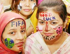 Pakistani girls with painted faces wish luck to the Iranian football team in Multan on Thursday
