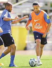 Brazilian striker Ronaldinho vies for the ball with team-mate Robinho during a training session in Konigstein