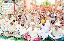 Members of the Forest Workers Union hold a dharna outside the office of the DFO to protest against the closure of nurseries in Pathankot on Tuesday.
