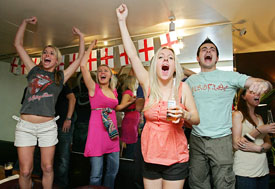 England fans celebrate in the Common Room Bar in Wimbledon in south London on Sunday as they watch England score against Ecuador