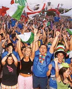 Italian fans celebrate while watching a giant screen televising the semifinal match between Italy and Germany