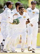Sri Lankan bowler Muttiah Muralitharan (centre) is congratulated by team-mates after the dismissal of South African captain Ashwell Prince on the final day of the first Test in Colombo on Monday.