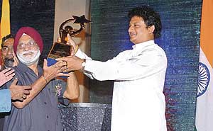 India�s Chef-de-Mission Rangil Singh (left) receives the South Asian Games champions trophy from Sri Lankan Sports Minister Jeevan Kumaratunga in Colombo on Sunday night.