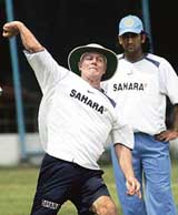 Greg Chappell demonstrates throwing techniques as Mahendra Singh Dhoni looks on during a practice session at the National Cricket Academy in Bangalore on Monday