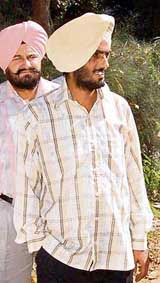 Junior Engineer Kulwant Singh with a Vigilance official in Mohali on Tuesday