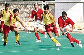 Punjab�s Jarnail Singh (right) gets past a Karnataka player during a knockout match of the 62nd National Hockey Championship at the Olympian Surjit Hockey Stadium in Jalandhar on Thursday. 