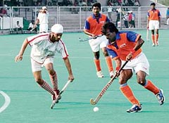 Dhanraj Pillay of Indian Airlines tries to dribble past a Namdhari defender during their match at the 62nd National Hockey Championship in Jalandhar
