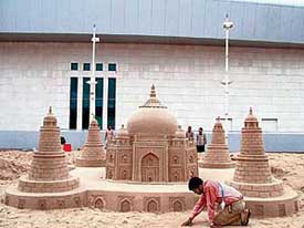 Indian sand artist Sudarshan Patnaik gives final touches to the sand sculpture of Taj Mahal in Doha on Friday. Patnaik has also created a replica of the games mascot, which attracted scores of visitors. Patnaik and his team of four students took three days and 100 tonnes of golden sand to create the 11-feet high and 15-feet long replica of Taj Mahal. 