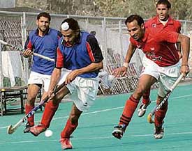 A Punjab Police player gets past a BSF player (red) during a league match of the Ramesh Chander Memorial Hockey Tournament at the Olympian Surjit Hockey Stadium in Jalandhar
