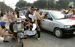 Members of the Substitute Computer Teachers Union, Punjab, beg from passers-by and polish shoes to mark a protest in Sector 34, Chandigarh, on Monday. 
