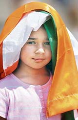 A young Indian girl covers herself with the Tricolour to beat the heat while watching the Sania Mirza-Olga Savchuk match in Melbourne