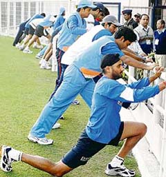 Harbhajan Singh and other Indian cricketers perform stretching exercises at the Vidarbha Cricket Stadium in Nagpur