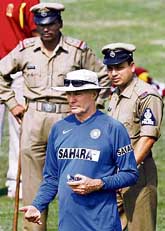 Greg Chappell attends a training session as police personnel stand guard in Cuttack on Tuesday.